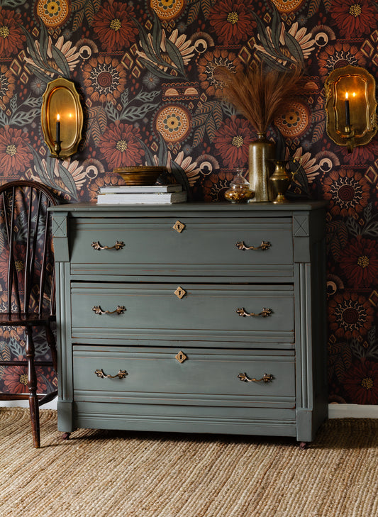 Windsor Green Homestead House Milk Paint dresser with gold handles against a dark patterned wall.