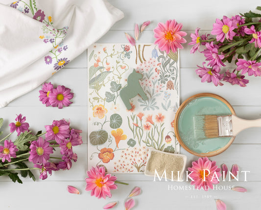 Decorative items with floral patterns and 'Milk Paint Homestead House' branding on a white surface.