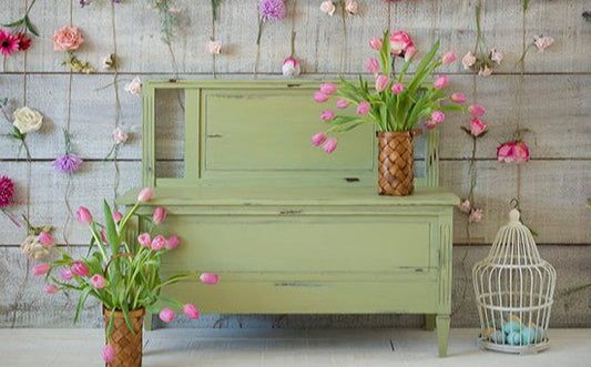Gatineau green bench seat with pink tulips in vases against a wooden wall with hanging flowers
