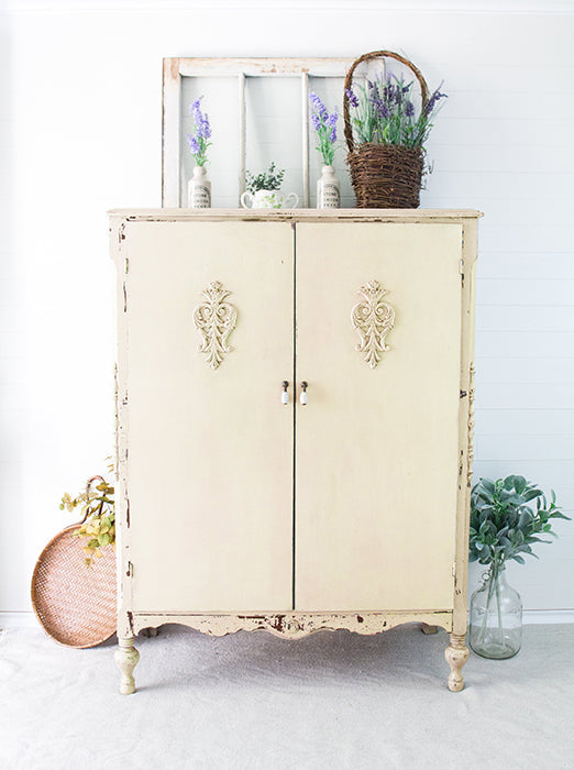 Vintage-style cabinet painted in Cartier homestead House Milk Paint with decorative elements on a white background