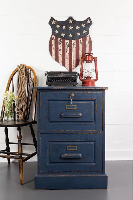 Chunky pine painted Liberty Blue Homestead House Milk Paint vintage-style filing cabinet with a red lantern and American flag decoration on a white wall.