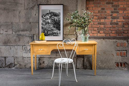 Mustard homestead House Milk Paint Wooden desk with a white chair against a brick wall.