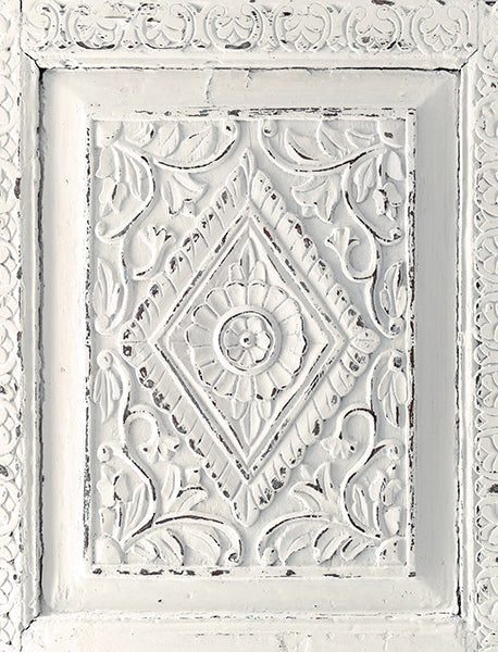 Decorative white panel with intricate carvings and patterns painted in Raw Silk Homestead House Milk Paint and distressed