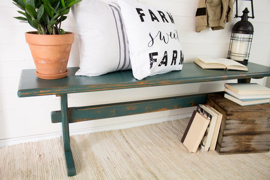 Waterloo Green bench with a potted plant, 'Farm Sweet Farm' pillow, and books in a home setting.
